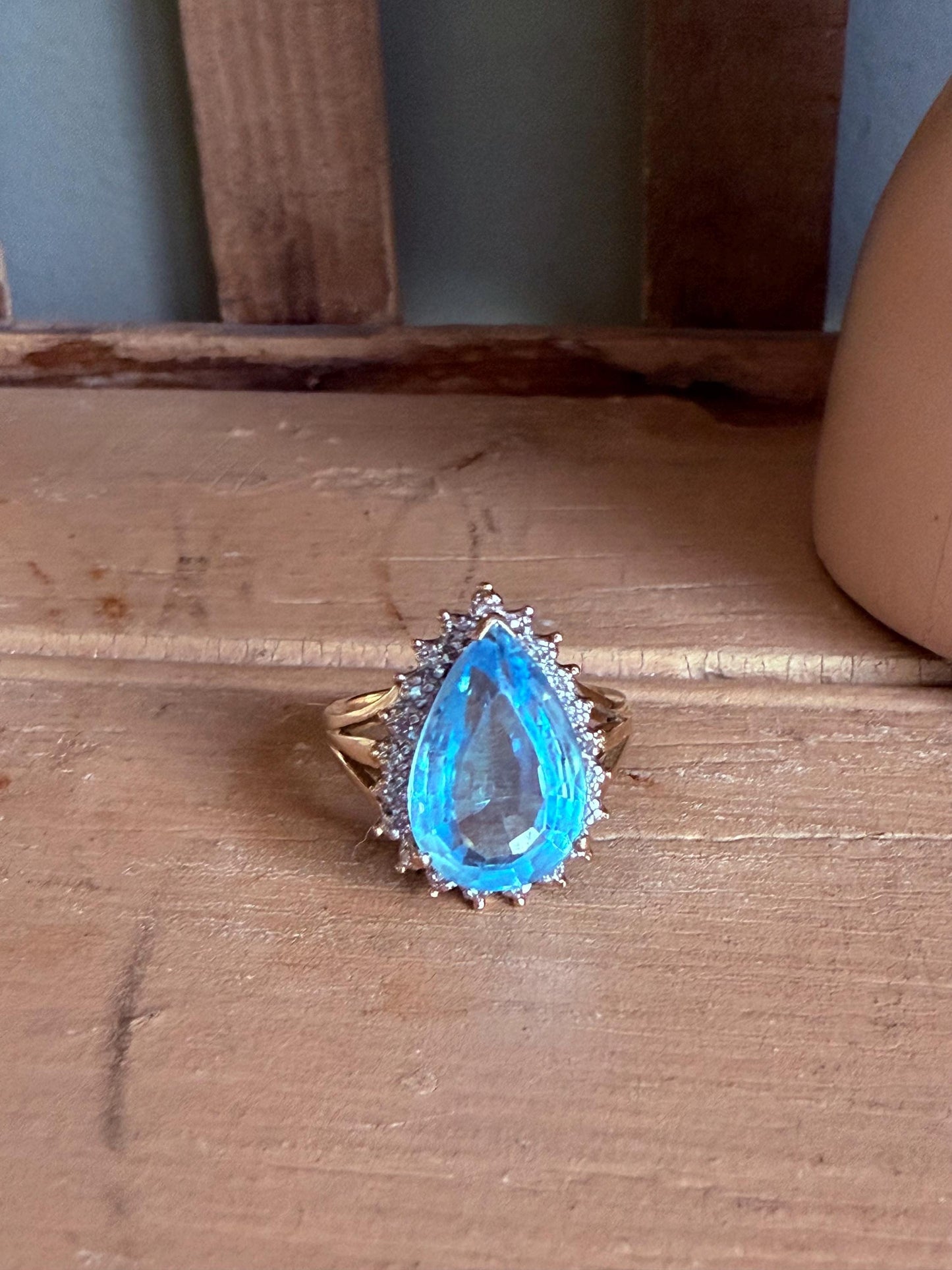 A Large Pear Shaped Blue Topaz Diamond Halo Ring in 10K Yellow and White Gold