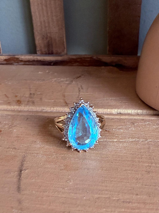 A Large Pear Shaped Blue Topaz Diamond Halo Ring in 10K Yellow and White Gold